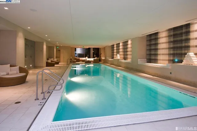 a living room with stainless steel appliances furniture a rug and a view of kitchen