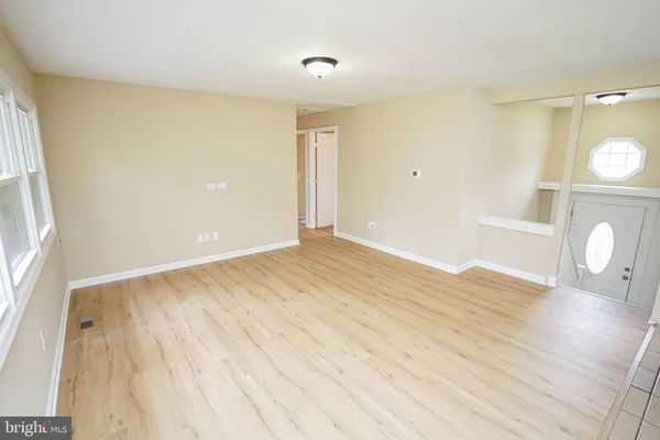 a view of empty room with wooden floor