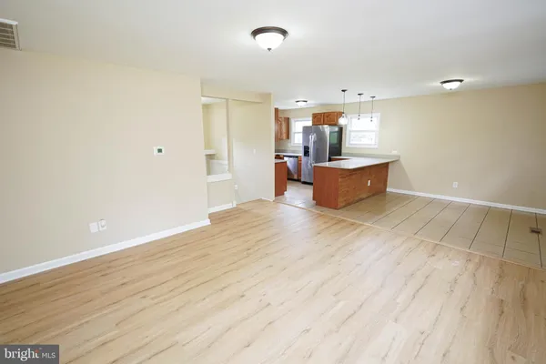 an empty room with wooden floor and window