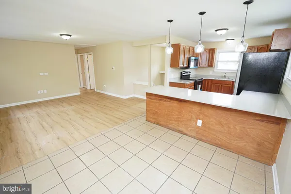 a kitchen with stainless steel appliances kitchen island granite countertop a refrigerator a oven and a sink with granite countertops