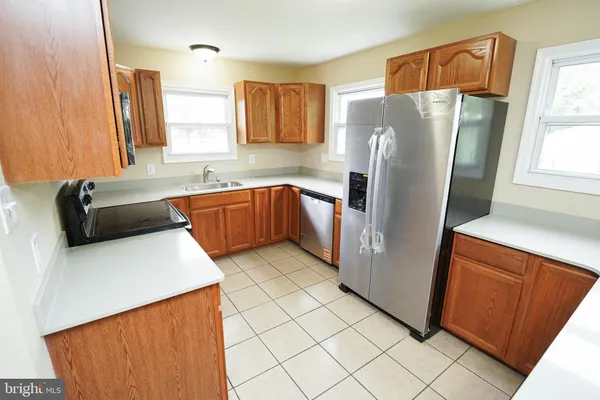 a kitchen with stainless steel appliances a refrigerator sink and microwave