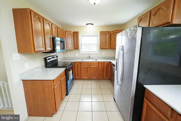 a kitchen with stainless steel appliances a refrigerator sink and microwave