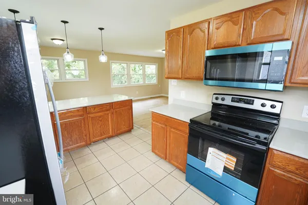 a kitchen with stainless steel appliances a stove a microwave and a sink