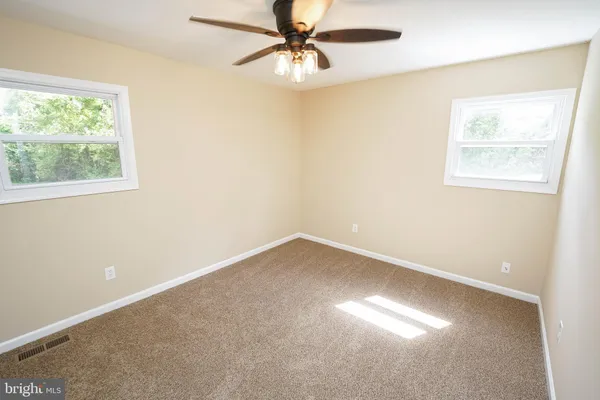 an empty room with a window and a fan