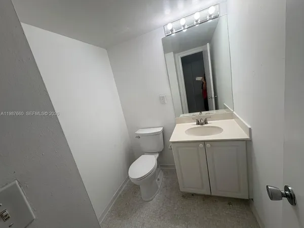 a bathroom with a sink mirror and toilet