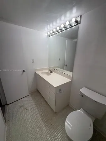 a bathroom with a sink mirror vanity and toilet