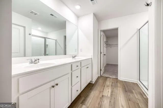 a spacious bathroom with a double vanity sink and mirror