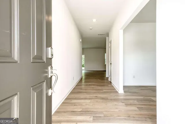 a view of a hallway with wooden floor and staircase