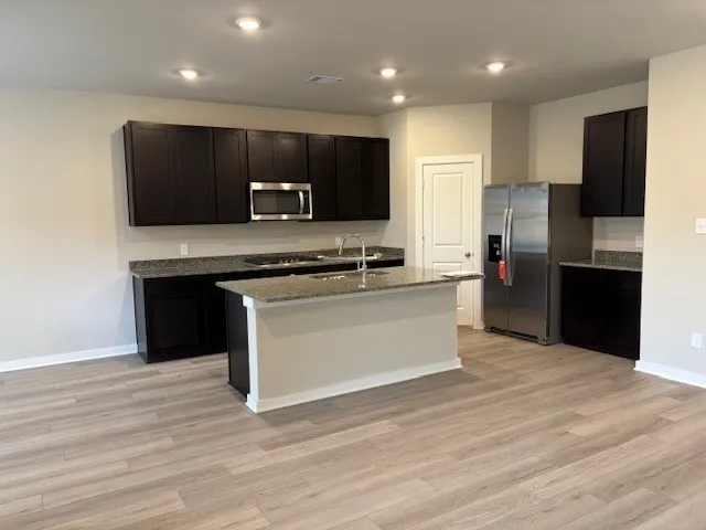 a kitchen with stainless steel appliances a refrigerator sink and microwave