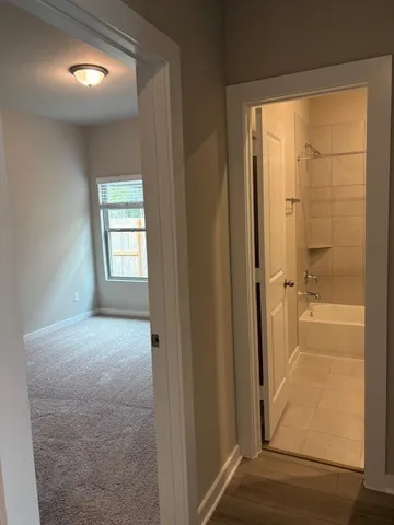a view of an empty room with closet and a window
