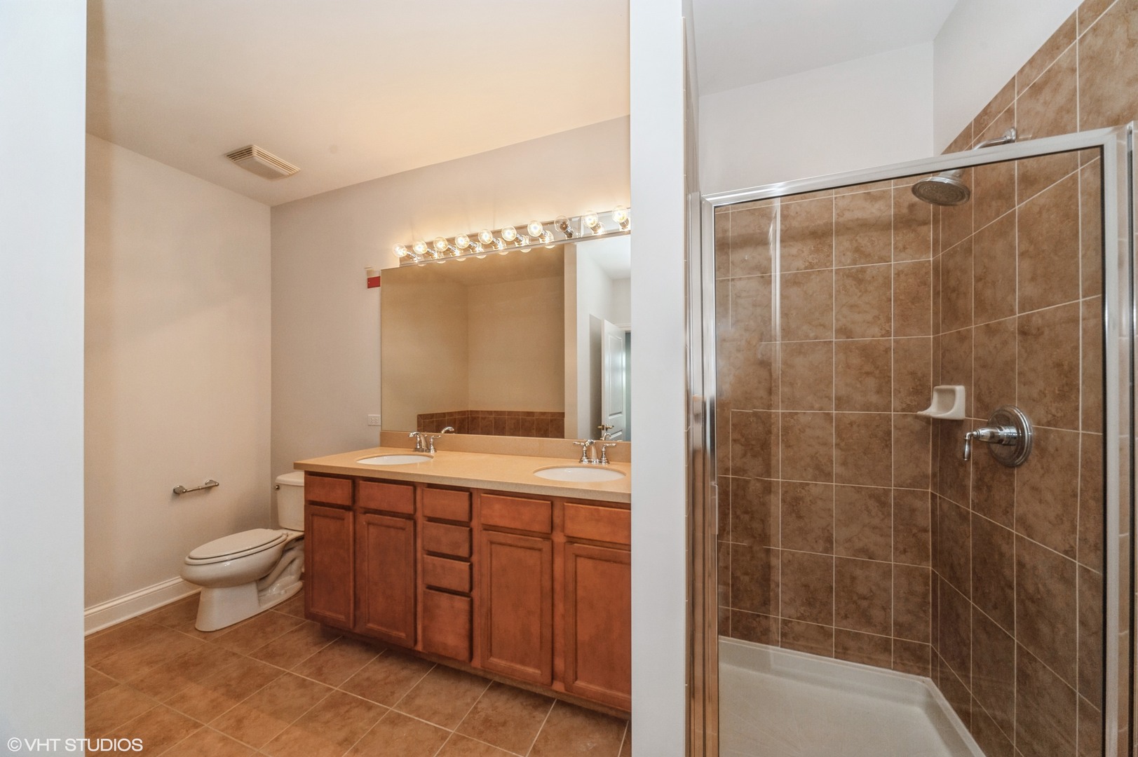115 Prairie Park Drive, Unit 407 Wheeling, IL 60090 - Photo 11 of 17 a bathroom with a double vanity sink a toilet and shower