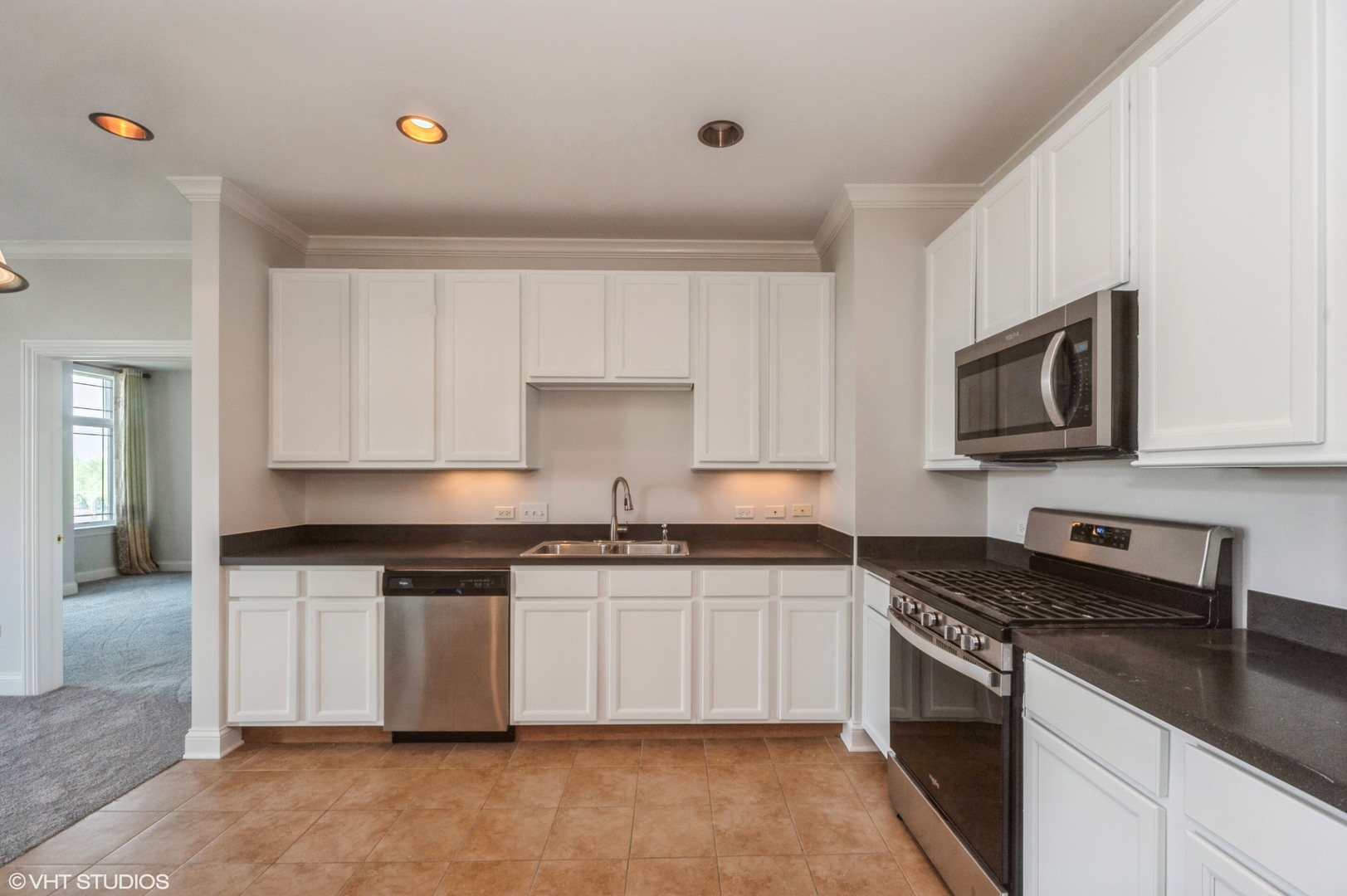 115 Prairie Park Drive, Unit 407 Wheeling, IL 60090 - Photo 4 of 17 a kitchen with stainless steel appliances granite countertop a stove a sink and a microwave