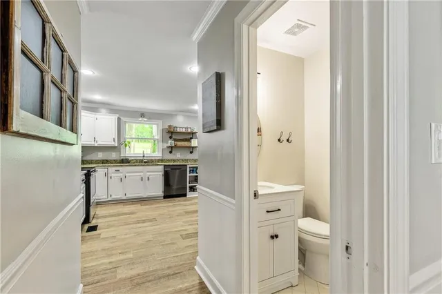 a bathroom with a granite countertop sink mirror vanity and toilet