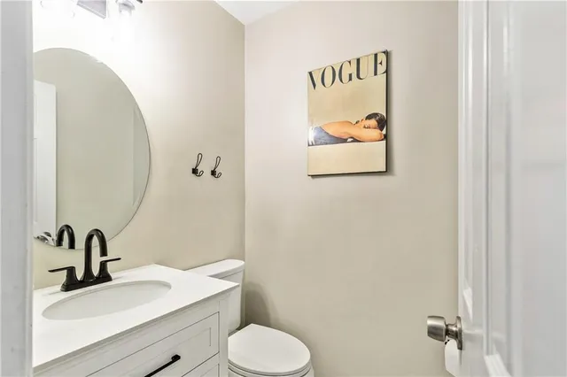 a bathroom with a granite countertop sink mirror and toilet