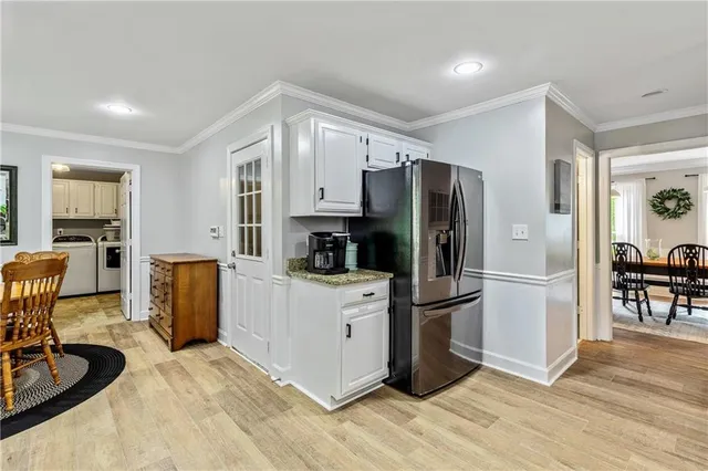 a kitchen with a refrigerator cabinets and wooden floor