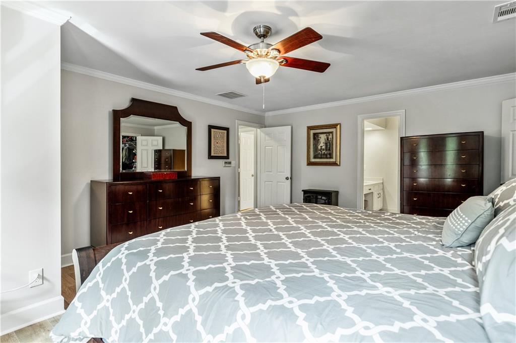 135 Crimson Ridge Tyrone, GA 30290 - Photo 33 of 53 a bedroom with a large bed and a chandelier