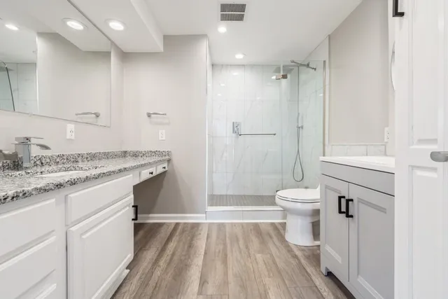 a bathroom with a sink a toilet and shower