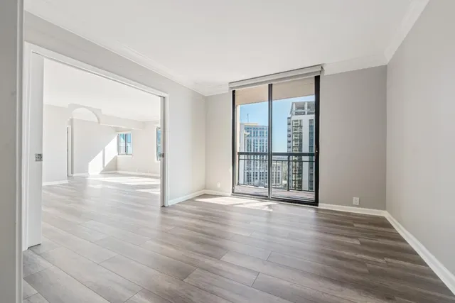 a view of a big room with wooden floor and windows