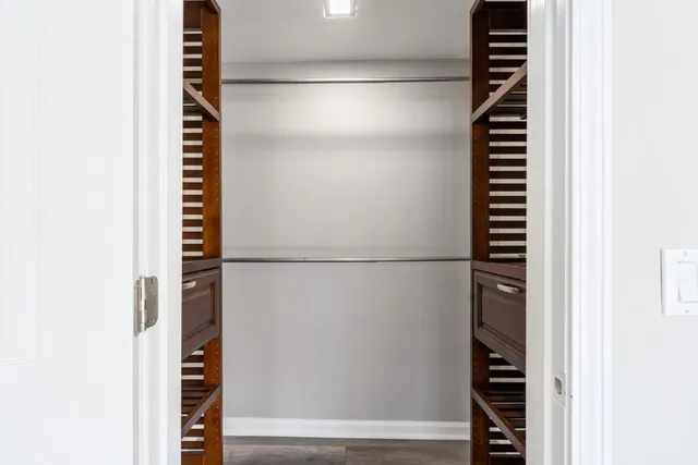 a view of walk in closet with clothes and shoes