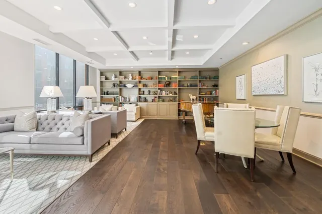 a living room with stainless steel appliances furniture large window and wooden floor
