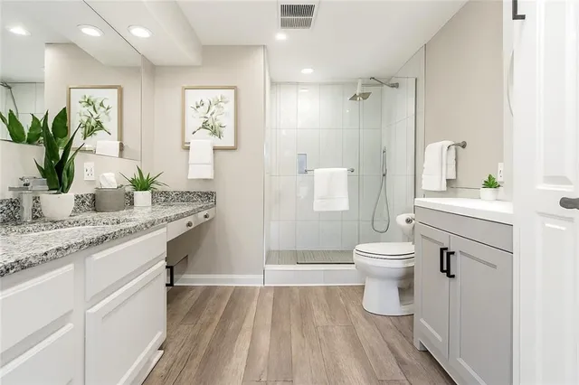 a bathroom with a granite countertop sink toilet and shower