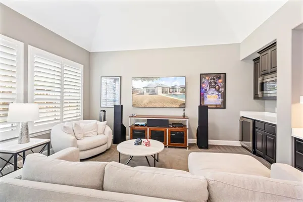 a living room with furniture a table and large windows