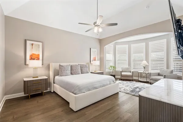 a spacious bedroom with a large bed and a chandelier