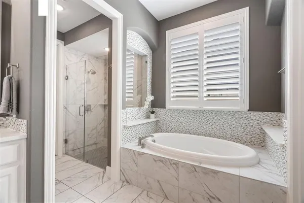a bathroom with a tub shower and sink