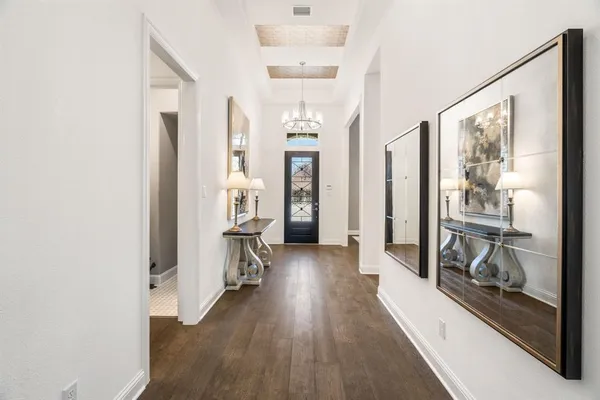 a view of a hallway with wooden floor and cabinet