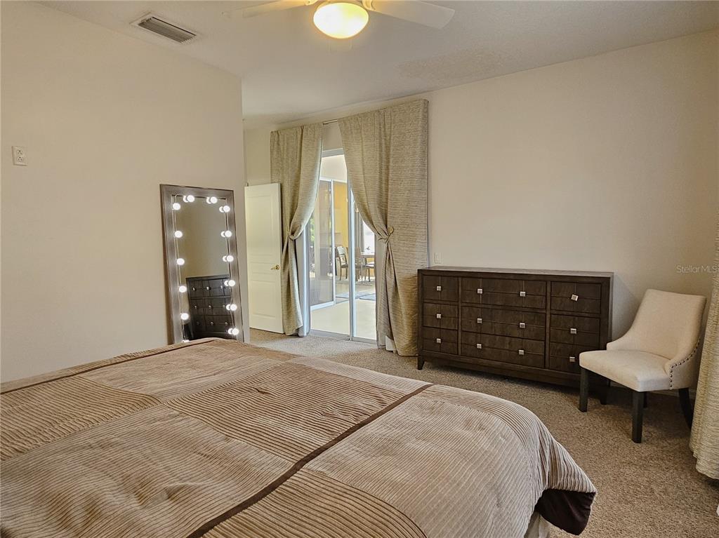 175 Braemar Avenue Venice, FL 34293 - Photo 22 of 40 a spacious bedroom with a bed and a couch