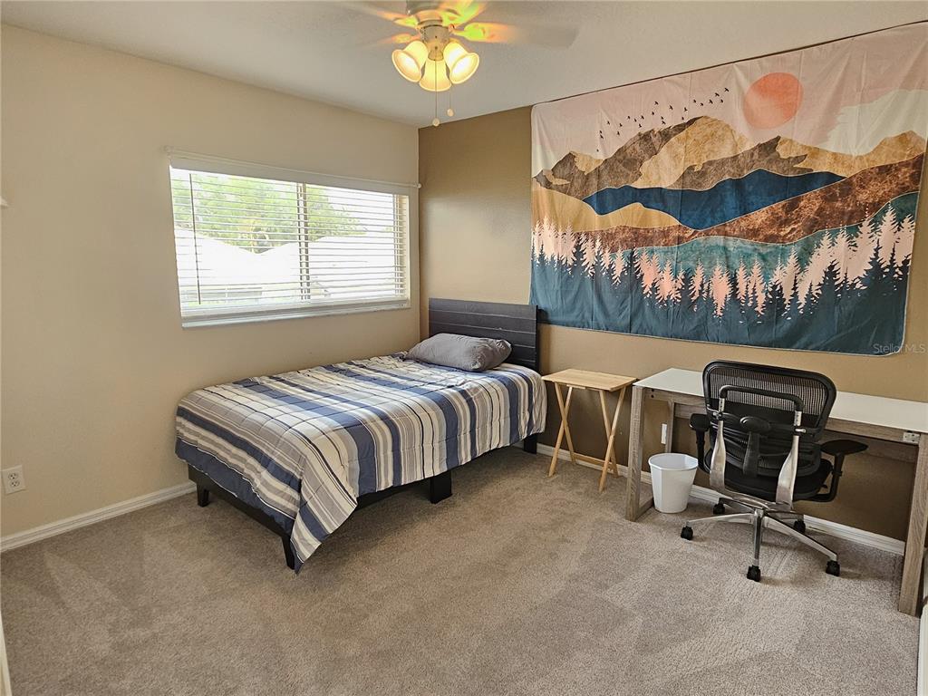 175 Braemar Avenue Venice, FL 34293 - Photo 35 of 40 a bedroom with a bed a chair and a chandelier