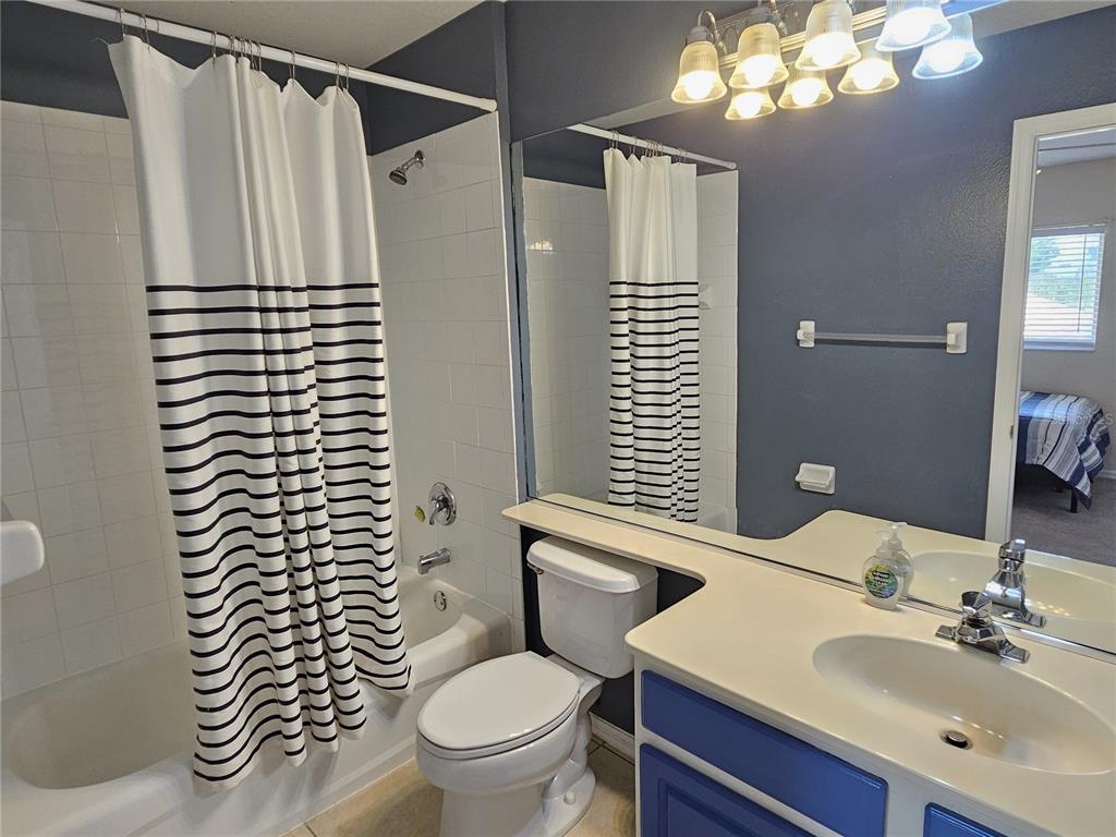 175 Braemar Avenue Venice, FL 34293 - Photo 37 of 40 a bathroom with a sink a toilet a mirror and shower curtain