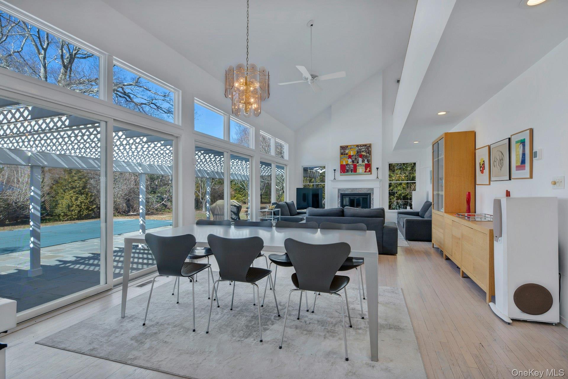 94 South Country Road Remsenburg, NY 11960 - Photo 11 of 40 Dining room with high vaulted ceiling, light wood finished floors, a glass covered fireplace, and a healthy amount of sunlight
