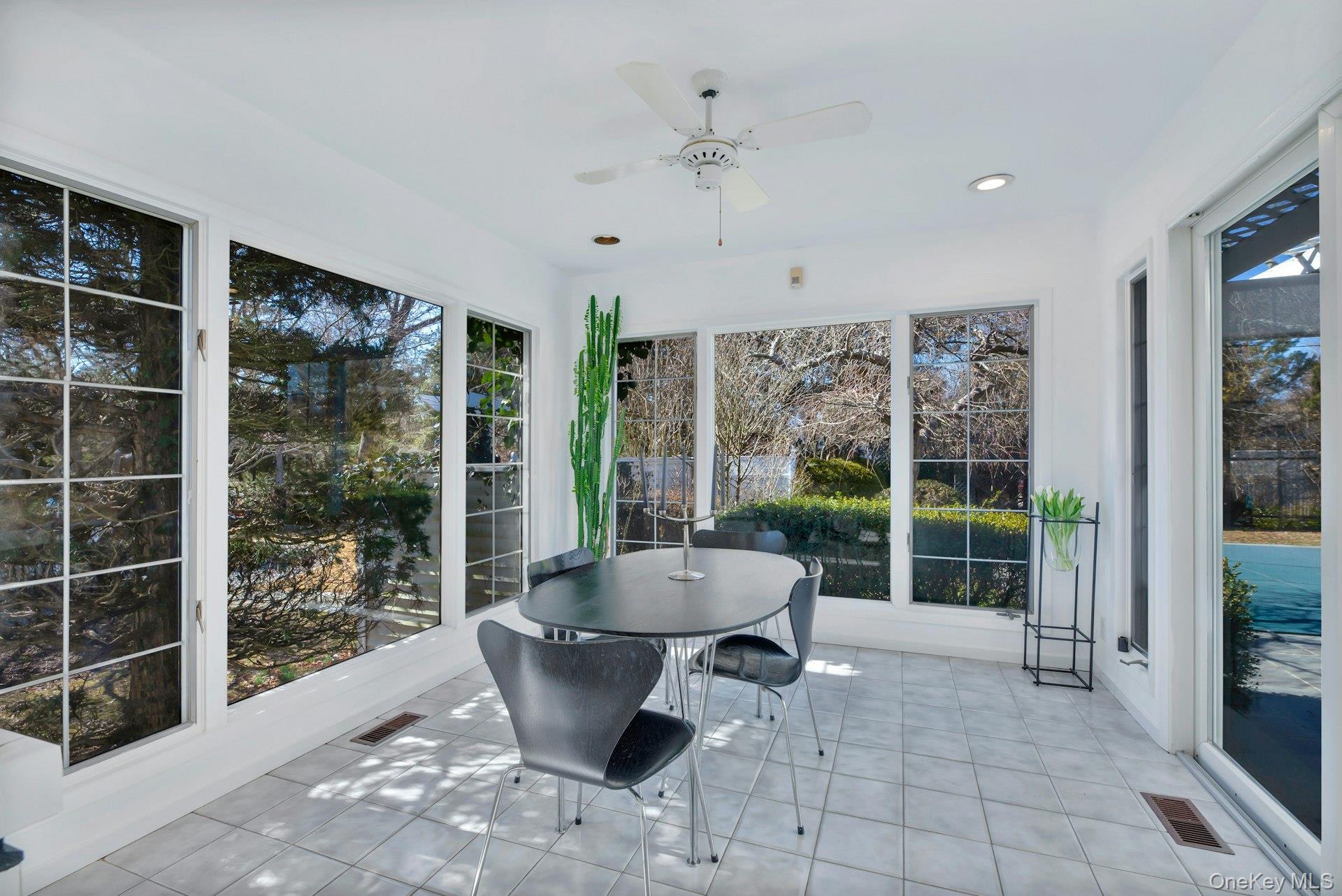 94 South Country Road Remsenburg, NY 11960 - Photo 17 of 40 Dining Area off Kitchen- Features of Sunroom/Solarium featuring ceiling fan with glass sliders to Patio, Pool, Tennis & Backyard