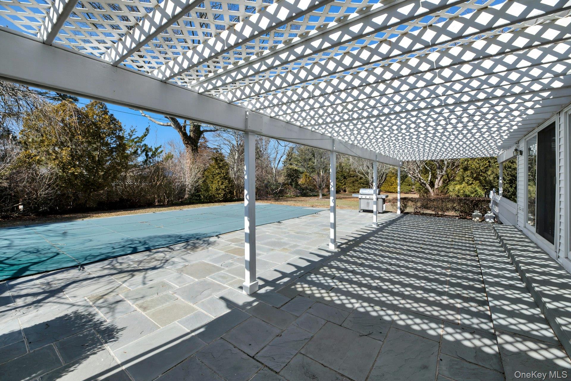 94 South Country Road Remsenburg, NY 11960 - Photo 5 of 40 Patio flanking great room with glass slider access to interior. View of patio featuring grilling area and a pergola