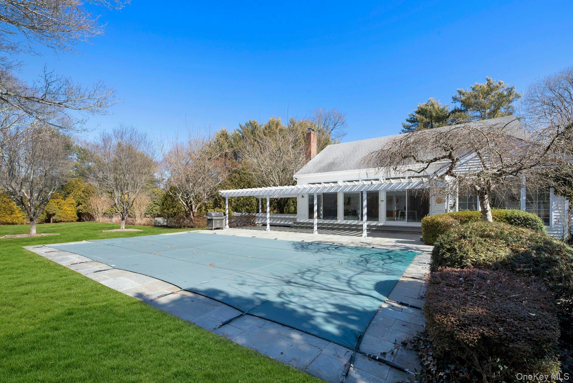 94 South Country Road Remsenburg, NY 11960 - Photo 6 of 40 Side overview of entertaining and recreation area featuring patio, pool, tennis, park like backyard