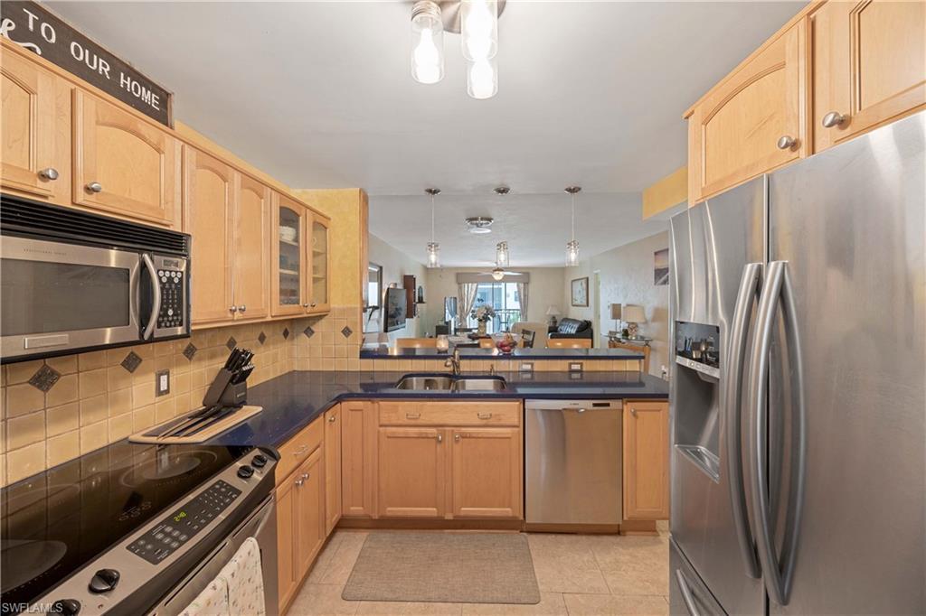 9395 Pennsylvania Avenue, Unit 3 Bonita Springs, FL 34135 - Photo 4 of 42 Kitchen featuring sink, light brown cabinets, decorative backsplash, light tile patterned flooring, and appliances with stainless steel finishes