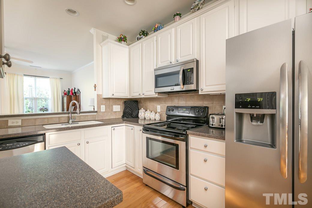 4834 Sir Duncan Way Raleigh, NC 27612 - Photo 5 of 27 Continuous hardwood floors lead into the kitchen.