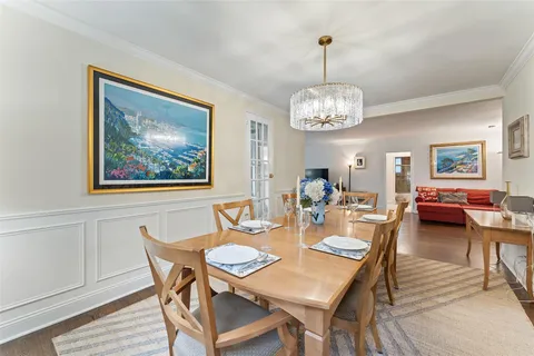 a view of a dining room with furniture a chandelier and wooden floor