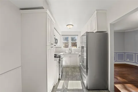 a kitchen with a refrigerator and a wooden floor