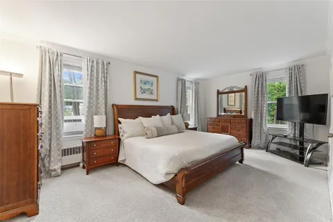 a bedroom with a bed and a flat tv screen on the dresser