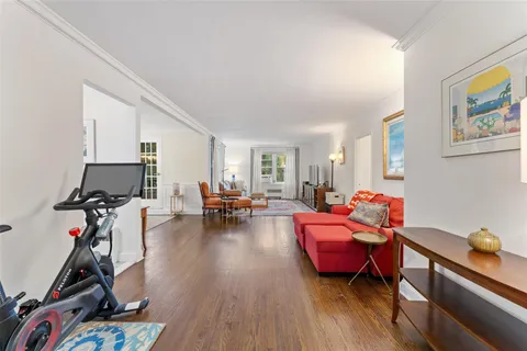 a living room with furniture a window and gym equipment