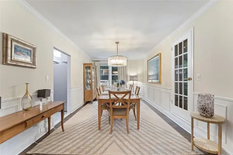 a dining room with furniture a chandelier and wooden floor