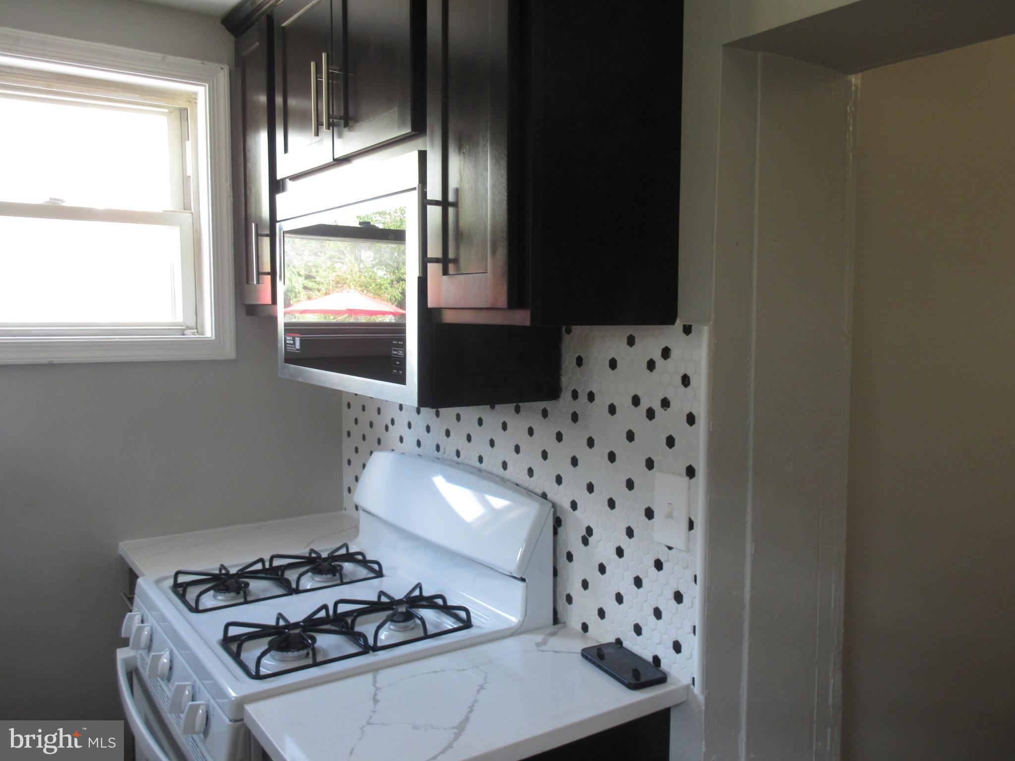 722 Edgewood Street Baltimore, MD 21229 - Photo 14 of 56 a kitchen with a stove and a microwave