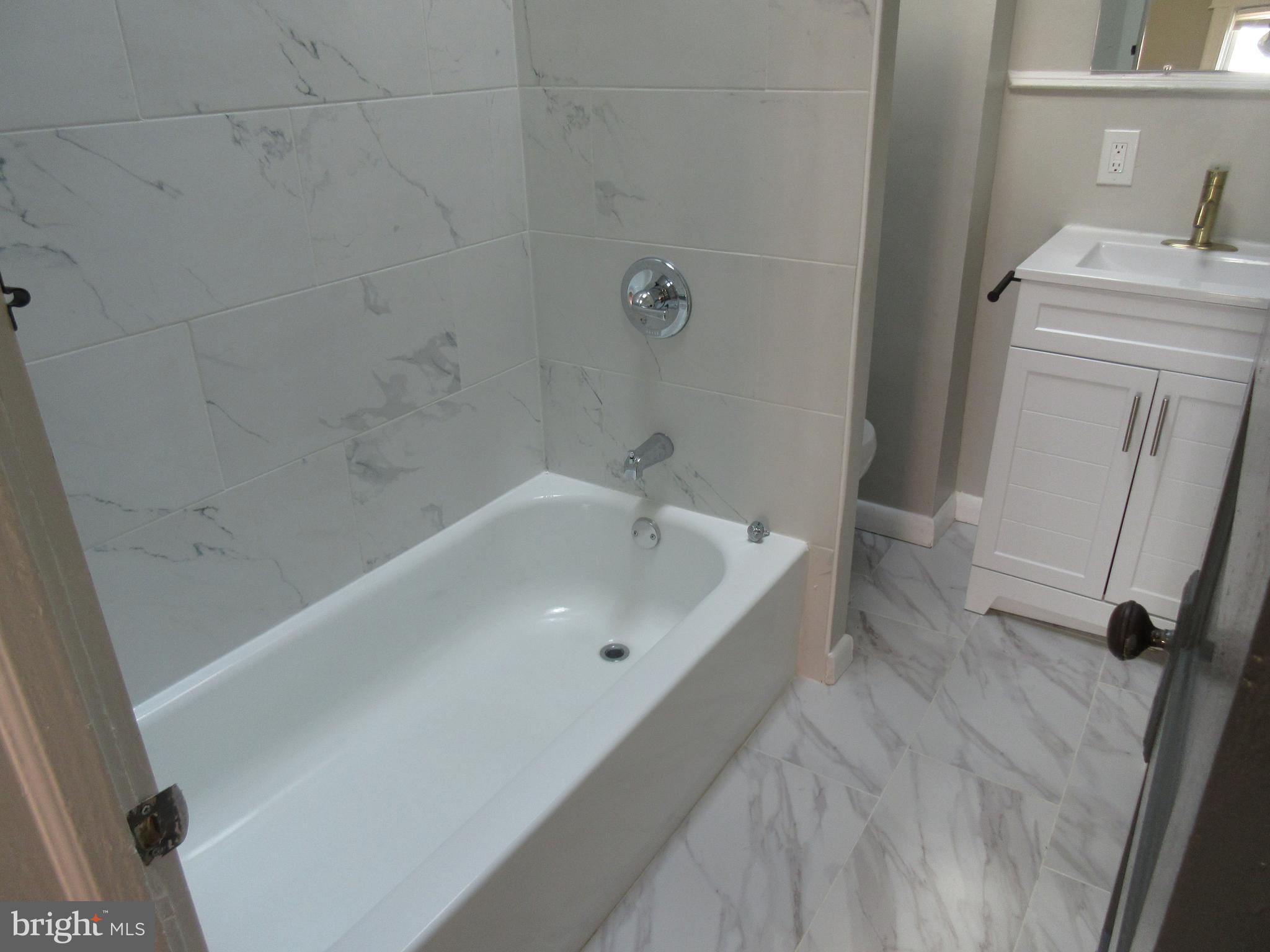 722 Edgewood Street Baltimore, MD 21229 - Photo 38 of 56 a bathroom with a sink a window and a shower