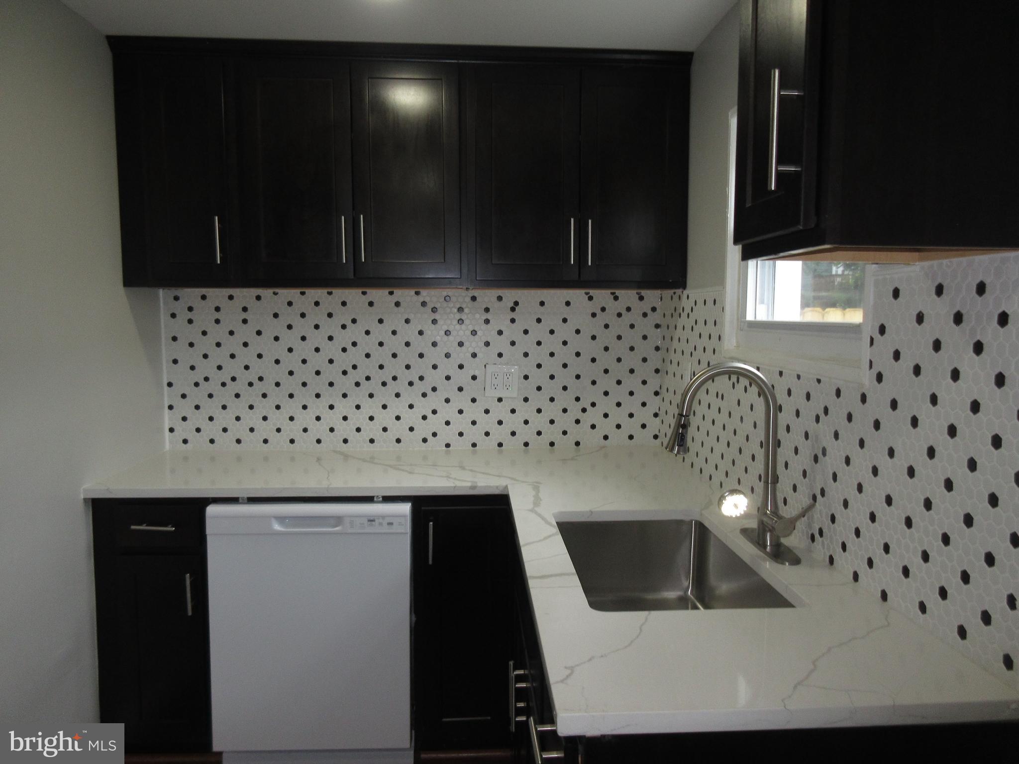 722 Edgewood Street Baltimore, MD 21229 - Photo 53 of 56 a kitchen with a sink a microwave and cabinets