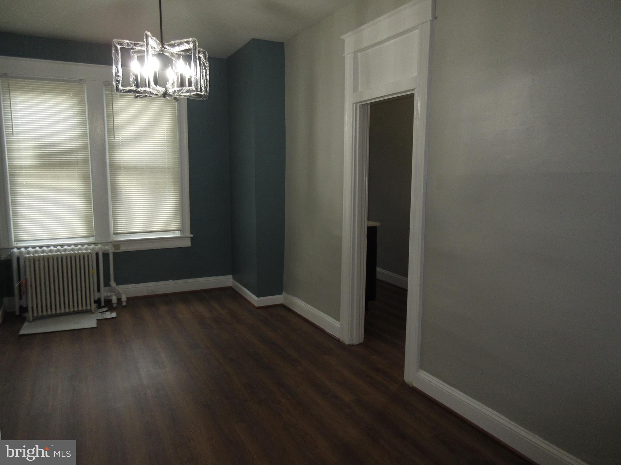 722 Edgewood Street Baltimore, MD 21229 - Photo 55 of 56 an empty room with wooden floor chandelier and windows