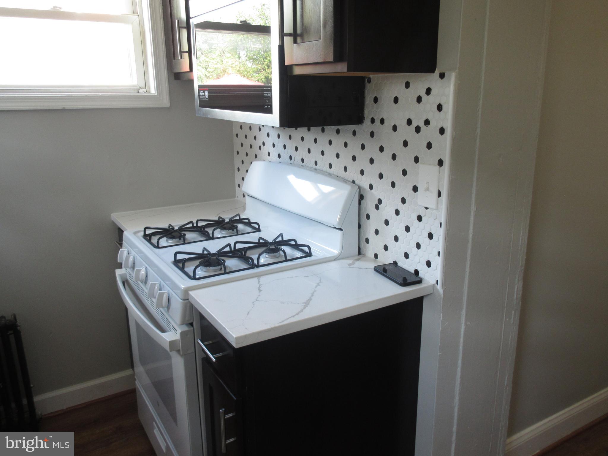 722 Edgewood Street Baltimore, MD 21229 - Photo 6 of 56 a kitchen with a sink a stove and a refrigerator