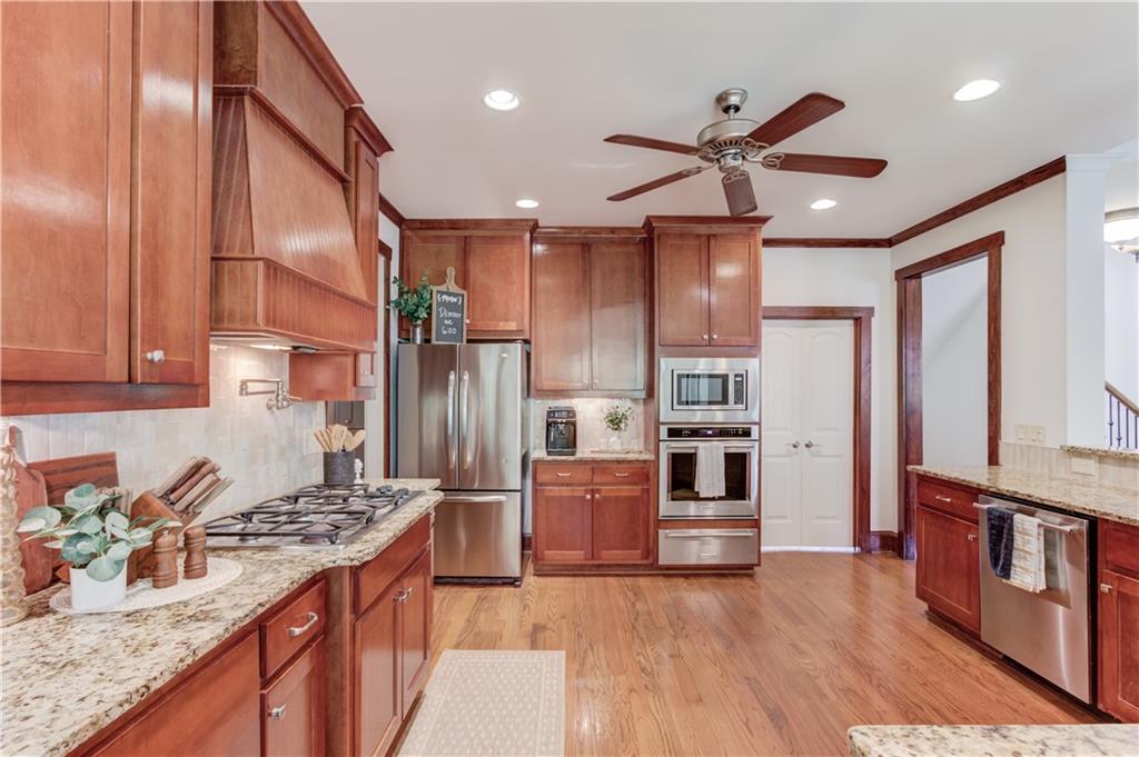 2240 Pear Grove Court Jefferson, GA 30549 - Photo 12 of 85 a kitchen with stainless steel appliances granite countertop a refrigerator a stove and a sink with wooden floors