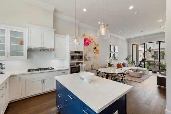 a kitchen that has a lot of white cabinets and wooden floor